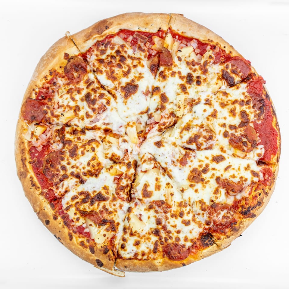 A whole Mangiamo La Pizza pepperoni and pineapple pizza, cut into slices, on a white background.